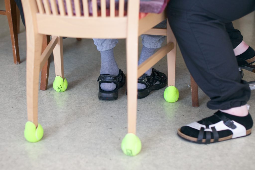 Tuolin jalat, jotka on pehmustettu auki leikatuilla tennispalloilla.