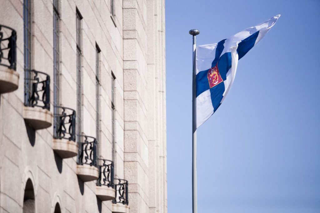 Suomen lippu liehumassa Eduskuntatalon edessä.