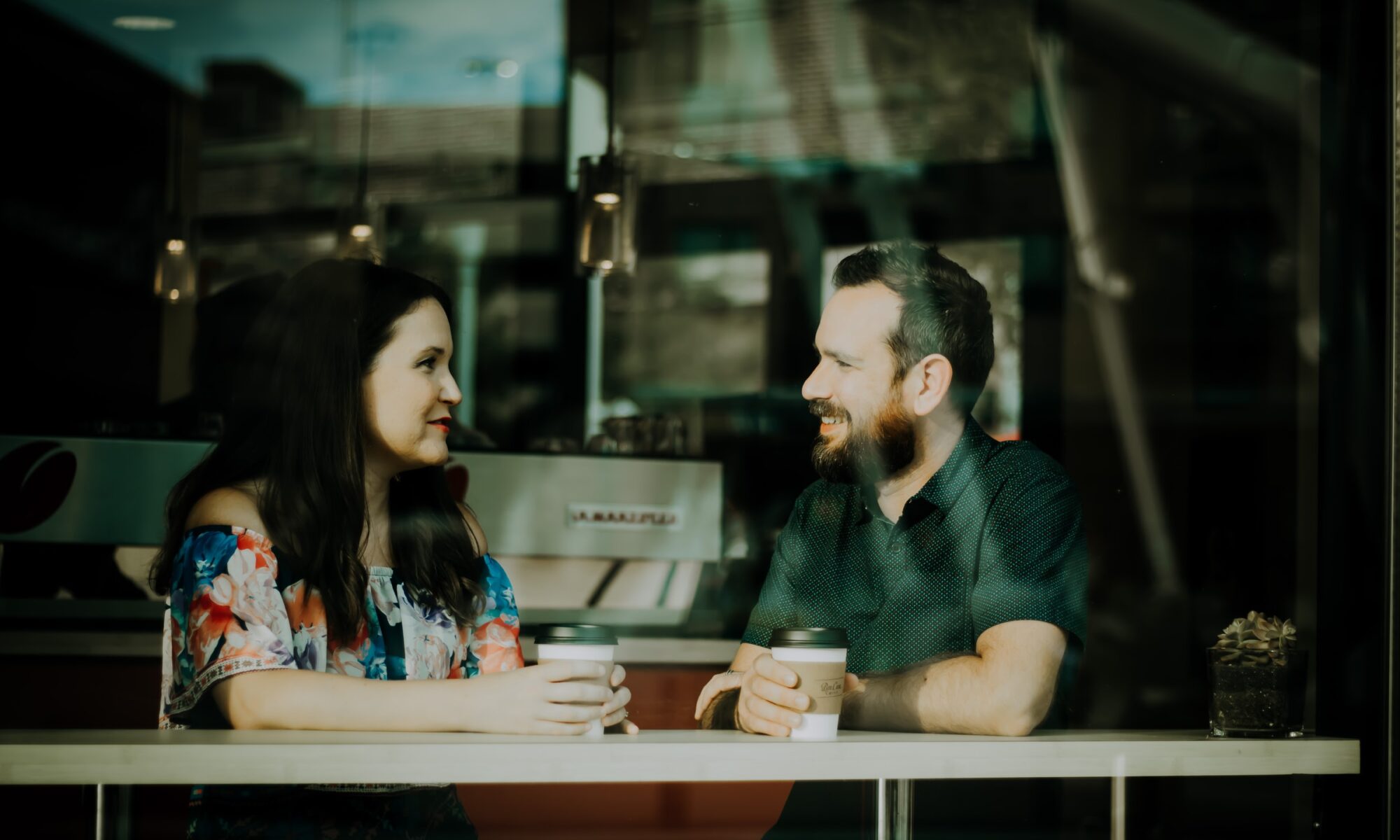Mies ja nainen juttelevat kahvilassa