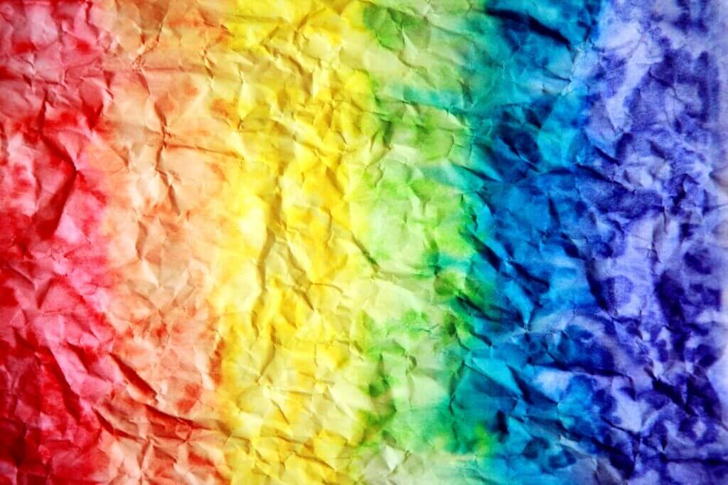 Rypistetty ja avattu paperi, joka on maalattu sateenkaaren väreillä.