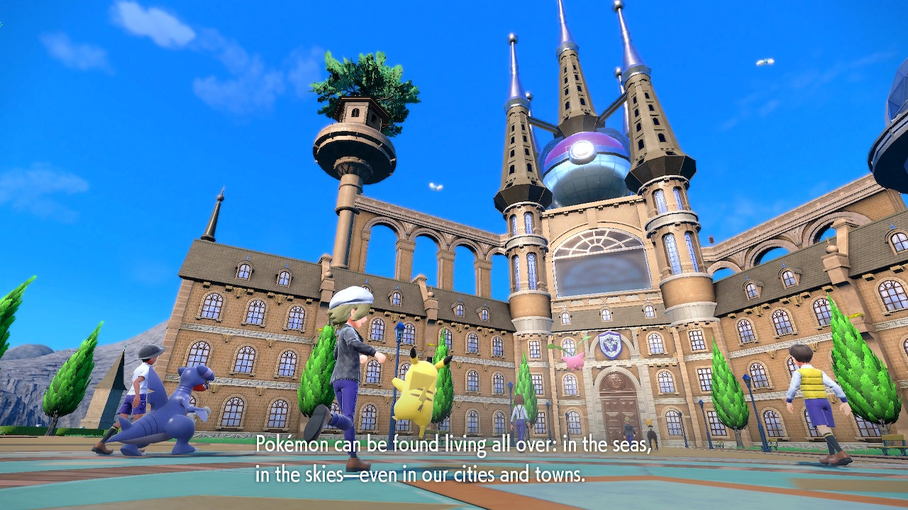 Kuvakaappaus Pokémon GO -pelistä. Pokémon-kouluttajia jylhän goottilaisen koulurakennuksen pihalla. Kuvateksti englanniksi: Pokémoneja voi löytää mistä vain: merestä, taivaalta, jopa meidän kylistämme ja kaupungeistamme.