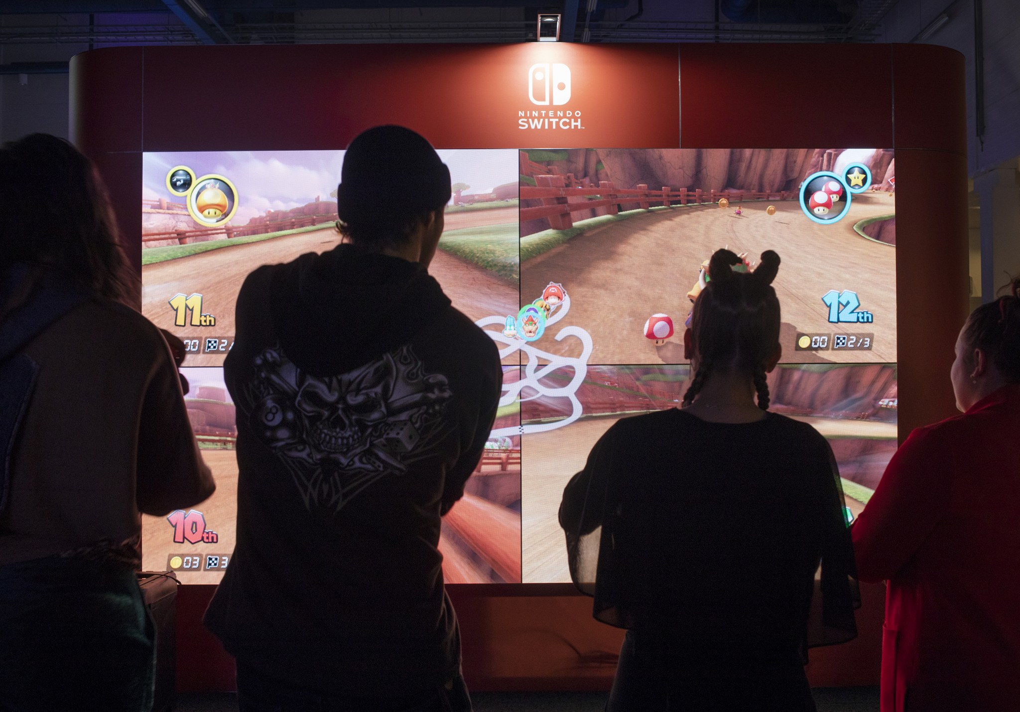 Neljä henkilöä pelaamassa Nintendo Switchin Mario Kart -moninpeliä.
