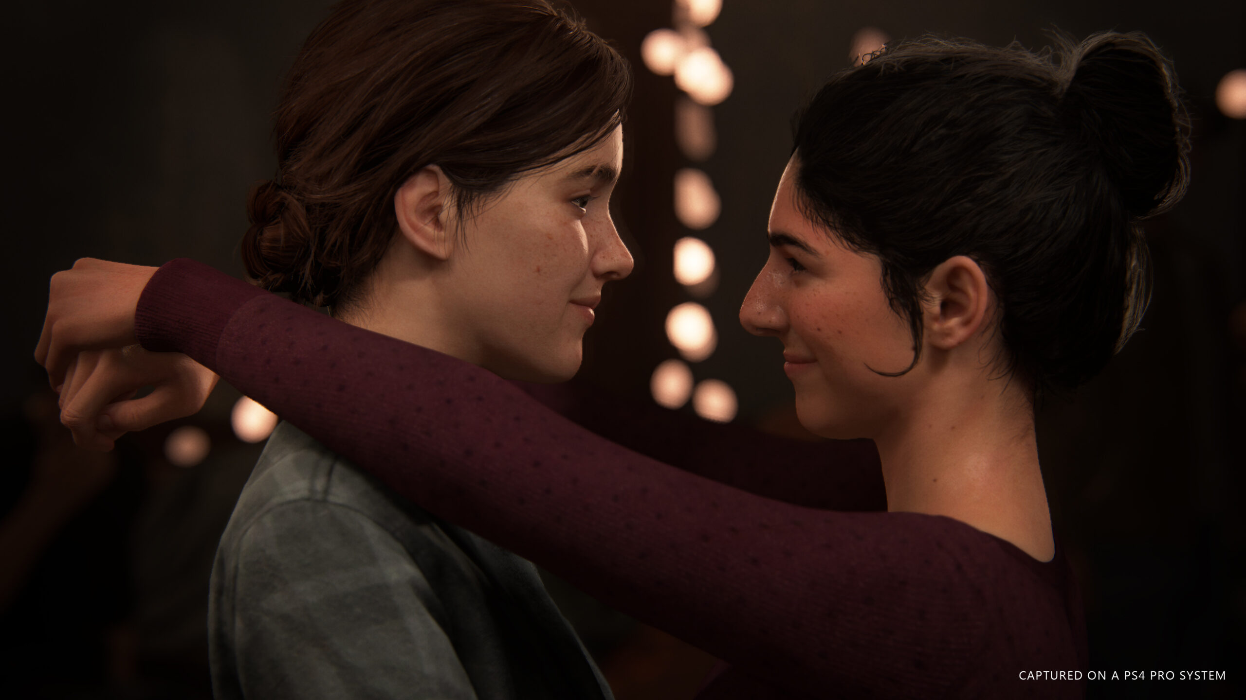 Kuvakaappaus The Last of Us -videopelistä. Kaksi naispuolista hahmoa syleilee toisiaan.