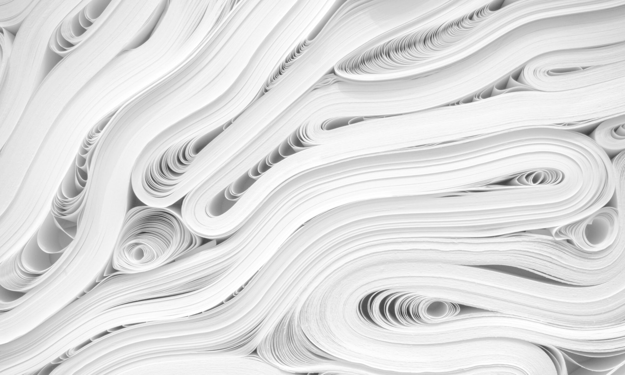 Kuvassa on kasa rullautunutta valkoista paperia.