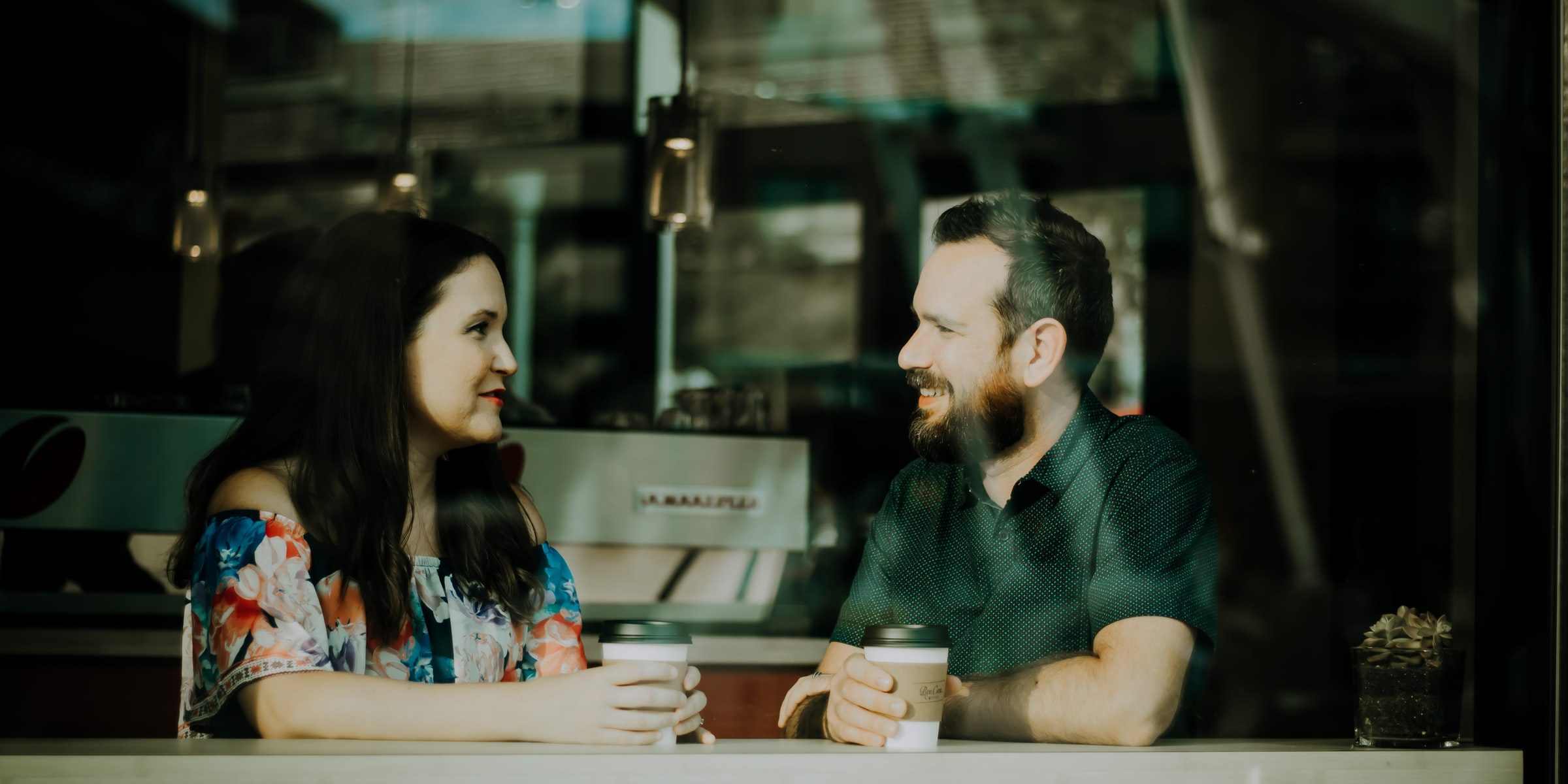 Mies ja nainen juttelevat kahvilassa