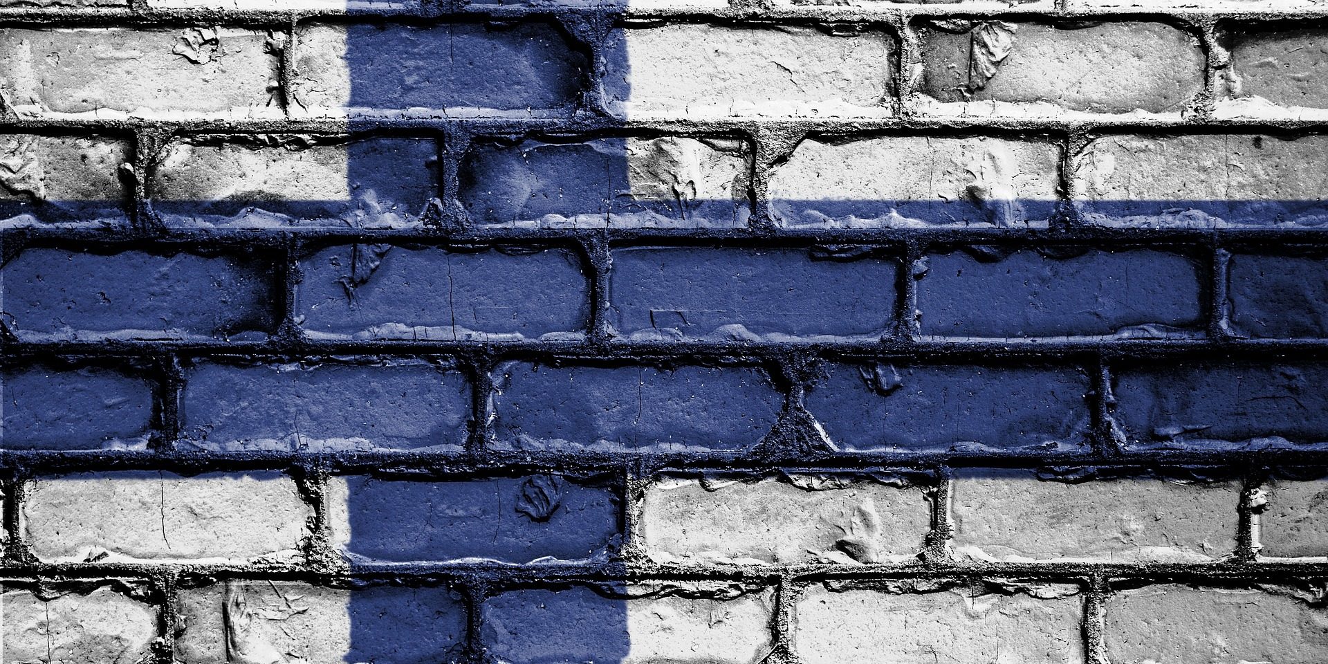 Suomen lippu maalattuna tiiliseinään.
