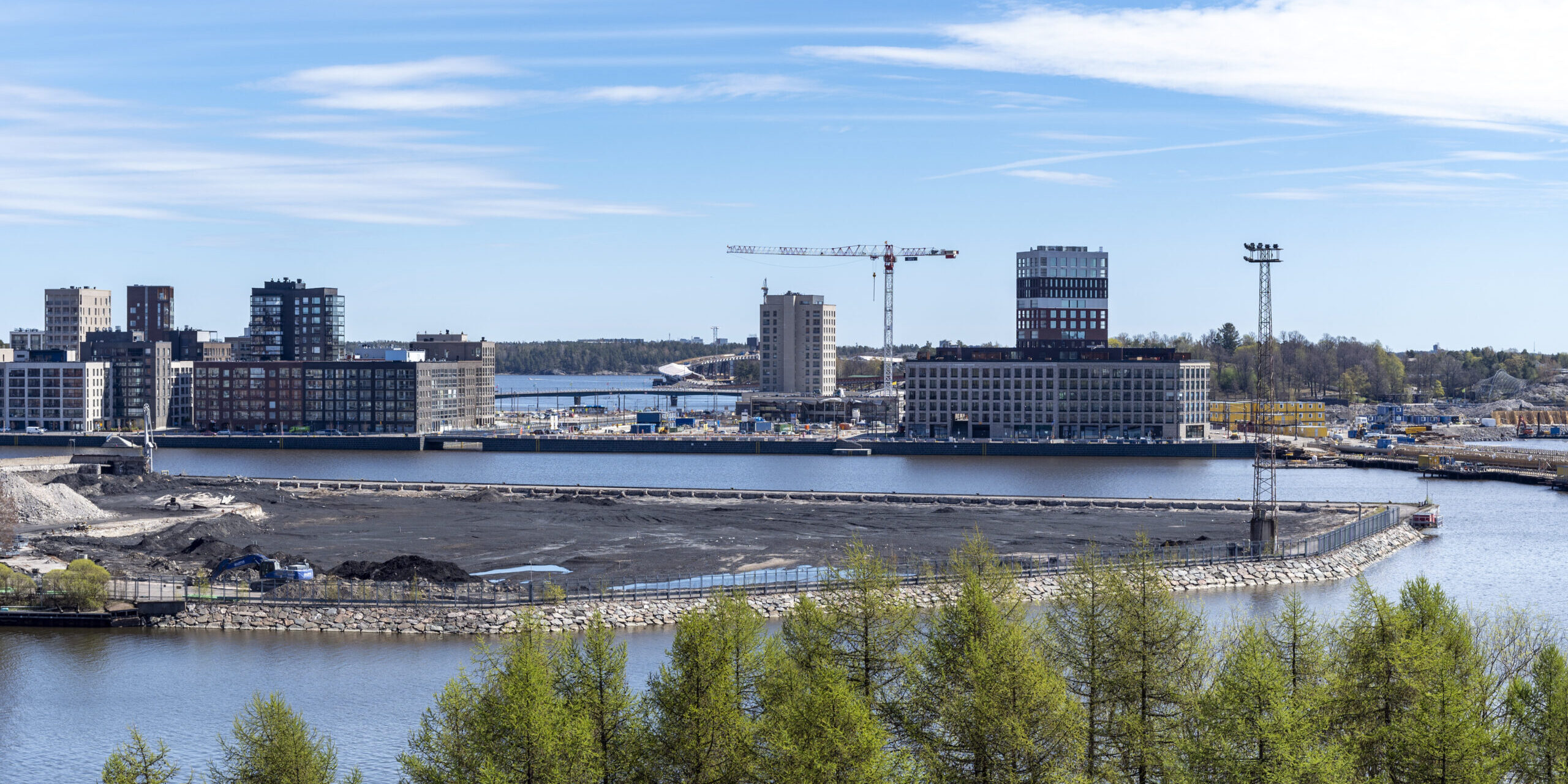 Keväällä 2023 toimintansa lopettaneen Hanasaaren voimalaitoksen hiilikenttä, alkamassa pilaantuneen maan vaihto. Näkymä Merihaan itärannan yli. Taustalla Sompasaari ja Nihti asuintaloineen ja torninostureineen. Nihdin kanavan aukko näkyvissä vasemmalla. Rakennusten takana Kruunuvuorensilta.